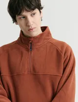 Sweater de micropolar color rojo, con cuello alto y cierre frontal parcial. Cuenta con mangas largas y bolsillos laterales con cierre.