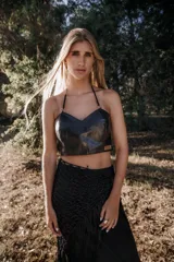 Top de cuero negro con escote en forma de corazón y tirantes finos ajustables que se anudan al cuello.