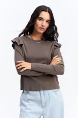 Remera de manga larga color marrón, con cuello redondo y detalle de volados en los hombros. Posee un corte ajustado al cuerpo.
