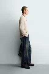 Jersey relaxed fit de punto acanalado color marrón oscuro, con cuello redondo tipo panadera y cierre frontal de tres botones. Tiene manga larga y efecto lavado.