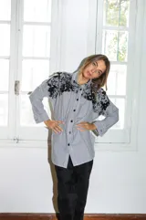 Camisa oversize a rayas verticales blancas y negras, con bordado de mostacillas negras en la parte superior.