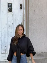 Camisa de lino color negro, con cuello con volados, mangas largas amplias y diseño con nudo frontal.