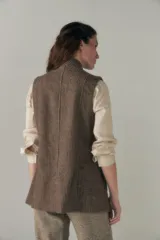 Chaleco color crema con solapas, corte entallado y bolsillos plaqué.