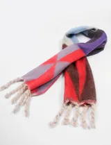 Bufanda larga rectangular con diseño color block en tonos rojo, azul, gris y blanco. Tiene flecos en los extremos.
