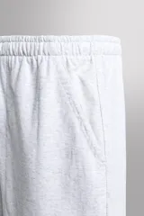 Pantalones cortos tipo jogger de corte relajado confeccionados en tejido de algodón. Presentan cintura elástica con cordón interior, bolsillos frontales en la cadera y un bolsillo trasero de plastrón.