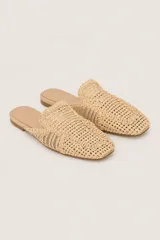 Sandalias tipo loafer destalonadas en color beige, confeccionadas con capellada trenzada efecto rafia, punta cuadrada y suela plana.