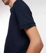 Chomba celeste de corte slim, confeccionada en tejido piquet texturizado de algodón, con cuello mao y cierre frontal parcial con botones.