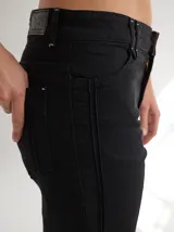 Pantalon de gabardina color beige, de corte recto y tiro medio. Presenta alforzas verticales en los laterales que recorren el largo de la pierna y cierre frontal con botón.