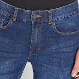 Jean slim de hombre color azul, con cierre de botón y cremallera, y bolsillos delanteros y traseros.