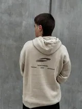 Canguro beige con capucha ajustable con cordones, bolsillo tipo canguro y estampado con diseño abstracto en negro.