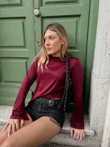 Remera bordó de manga larga con corte en la bocamanga y terminación en pico.