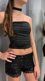 Top strapless negro con diseño fruncido al cuerpo.