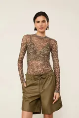 Top de tul estampado con cuello redondo alto y mangas largas, de tejido semitransparente y calce ajustado al cuerpo.