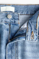Jeans de corte barrel en denim de algodón, de tiro medio y diseño holgado con piernas curvas. Presenta diseño de cinco bolsillos, trabillas para cinto y cierre frontal con botón y cremallera.