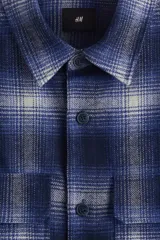 Sobrecamisa de franela suave con cuello inglés, tapeta lisa y bolsillos superiores con solapa. Presenta mangas largas con puños abotonados, canesú en la espalda y bajo recto.