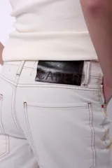 Pantalón de jean tipo wide leg con efecto de lavado degradado en tonos beige y blanco. Presenta tiro medio, corte recto y amplio, con costuras reforzadas.