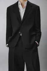 Blazer regular fit de lana color negro, con solapas de muesca, cierre frontal de un botón, bolsillos con solapa en la cadera y manga larga.