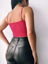 Top fucsia con copas de crepé y red en el centro.