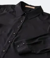 Camisa básica de crepé color negro, con cuello inglés, mangas largas y abotonado frontal.