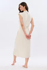 Vestido midi de lino color beige, sin mangas, con cuello solapa, cierre frontal de botones y bolsillos en el pecho.