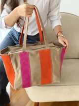 Bolso tipo shopper de diseño amplio, confeccionado en gamuza con un patrón de franjas verticales en tonos marrón oscuro, rosa y verde oliva. Cuenta con doble asa de hombro y cierre superior.