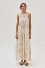 Vestido largo de red color crudo con estampado de flores, corte recto y cuello halter.