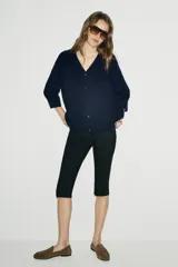 Chaqueta tipo cardigan de lana color azul marino, con cuello en pico, cierre frontal con botones y mangas abullonadas de largo tres cuartos.