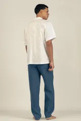 Camisa estilo camper, de fit boxy, confeccionada en popelina con estampa de mármol celeste y blanco. Tiene cuello tipo camp-collar y botones de madera.