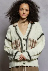 Cardigan de tejido de punto grueso color crema, con cuello tipo camisa y cierre frontal de botones florales. Presenta detalles deshilachados y teñido tipo tie-dye en tonos grises oscuros en el frente y puños. Tiene parches cuadrados de tela a cuadros en tonos tierra sobre los bolsillos delanteros.