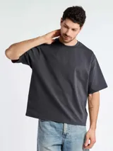 Remera de corte oversize y cuello redondo, confeccionada en tejido de algodón de alta calidad. Presenta un diseño minimalista y liso con mangas cortas de caída amplia.
