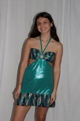 Vestido corto azul metalizado con diseño cut-out, argolla central en el busto, tirantes halter y falda con volado en el ruedo.