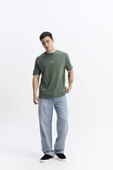 Remera de manga corta color gris oscuro, con escote redondo y fit regular. Presenta un estampado frontal con el texto "new season designed and produced by mistral".