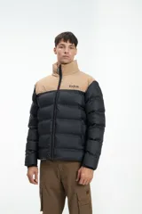 Campera puffer negra y beige con cierre frontal y cuello alto. Estampado con la marca "Unfrm" en el pecho.