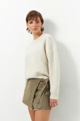 Short pollera de jean prelavado color negro, con lazo en uno de sus laterales y detalle de flecos en las terminaciones.