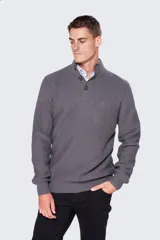 Buzo gris de tejido grueso con cuello alto y cierre parcial de botones. Cuenta con detalles en cuero y logo bordado en el pecho, mangas largas y puños acanalados.