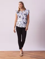 Blusa de algodón estampada con flores en tonos celeste y azul, cuello mao, escote en V, abertura frontal con botones y volados en las sisas.