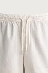 Bermuda de algodón en color beige, con corte relaxed fit, cintura elástica con cordón ajustable y bordado a tono en la pernera.