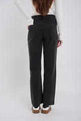 Pantalón de jean negro gastado, de corte recto, con bolsillos delanteros y sin trabillas.