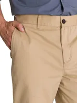 Pantalón chino Caterpillar de corte tapered straight, color beige, con tiro medio, bragueta con cremallera y botón, bolsillos laterales y bolsillos traseros con solapa y botón.
