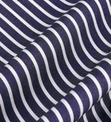 Short tipo bóxer de popelina de algodón a rayas verticales azules y blancas, con cintura elástica, botones frontales y logo bordado en blanco. Confeccionado en Portugal.