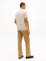 Chomba Tommy Hilfiger de color beige claro con textura de panal de abeja, cuello tipo polo con escote en V sin botones y manga corta.