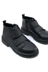 Bota corta negra de cuero con ajuste de velcro y suela track.