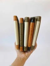 Billetera de cuero con diseño tricolor en tonos negro y marrón. Presenta una solapa central con textura acolchada y un parche con el logo de la marca, flanqueada por paneles laterales con textura de reptil. Incluye cierre con broche y monedero externo.