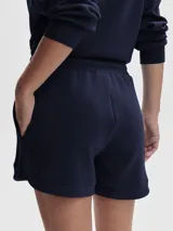 Buzo deportivo de tejido DoubleSoft®, color azul marino, con cuello alto con paneles y media cremallera plateada. Presenta un corte oversize y puños amplios con bajo.