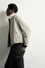 Cazadora cropped fit para hombre con estampado a cuadros, cuello subido, cierre frontal con cremallera y bolsillos con solapa en la cadera.