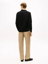 Chomba de manga larga Tommy Hilfiger de color negro, confeccionada en algodón orgánico con tejido de estructura estacional texturizada. Presenta cuello tipo chomba con cartera sin botones y el logo de la marca bordado discretamente en el pecho.