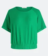 Blusa cropped de Marfinno color verde, con cuello redondo, mangas cortas con doblez y elástico en el bajo. Presenta un diseño texturizado con mangas raglán.