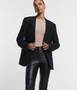 Pantalón tipo legging de mujer, color crema claro, confeccionado en poliuretano (PU) con un diseño liso. Presenta un cierre frontal con botones visibles en la cintura.