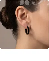 Aros tipo argolla de tamaño pequeño, con diseño minimalista en color negro brillante y detalle metálico en el cierre.