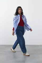 Jean de corte barrel con silueta curva y volumen controlado, de tiro medio y color negro. Presenta un diseño que se ensancha en la pierna y se ajusta levemente en el bajo, con cierre frontal y bolsillos laterales.